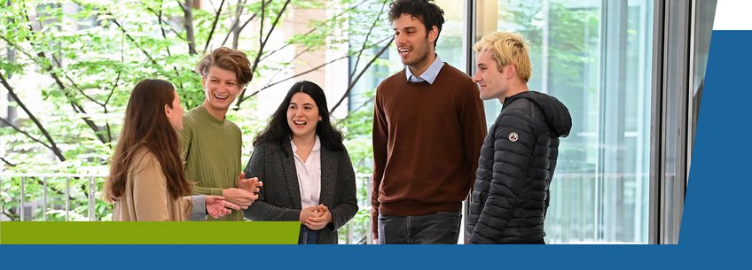IMPRS-SPCE, Calls for Applications A group of five young adults is engaging in a cheerful conversation indoors, with greenery visible through large windows.