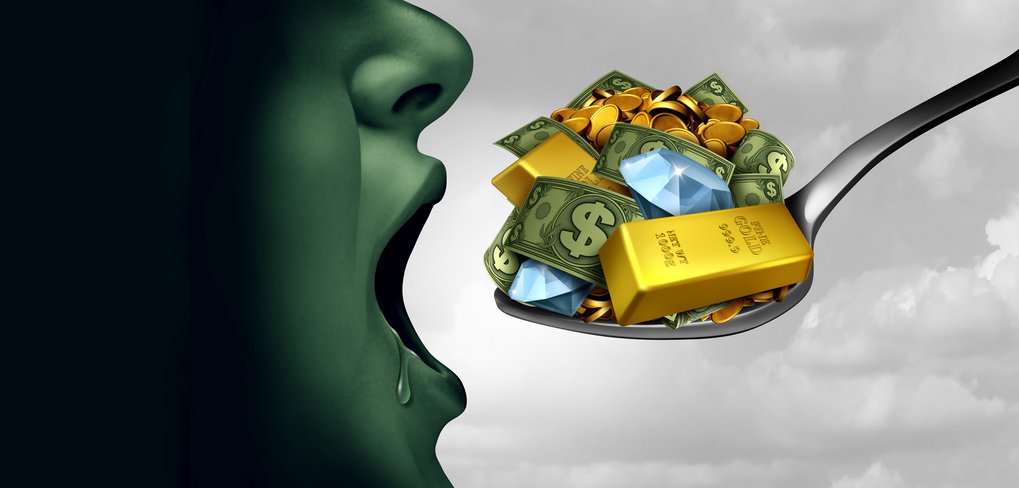 A green-tinted face moves towards a spoon heaped with dollar bills, gold bars, coins, and diamonds against a cloudy backdrop.
