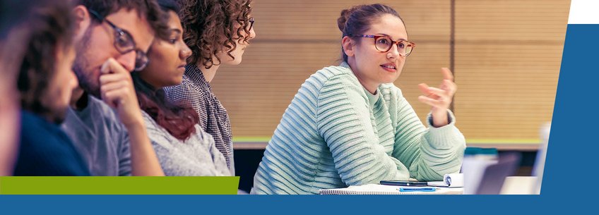 Courses Individuals in discussion, one gesturing while talking, seated at a table with notes.