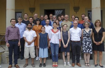 © MPIfG A group photo of approximately 30 people posing together outside a building, with some wearing casual attire and others in formal clothing.