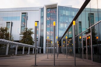 Modern building with glass facade and illuminated posts.