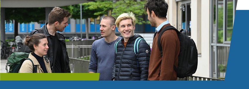 IMPRS-SPCE, Academic Coordination A group of five young adults are standing outdoors, engaged in conversation and smiling. They are casually dressed, with backpacks, and appear to be enjoying their time together.